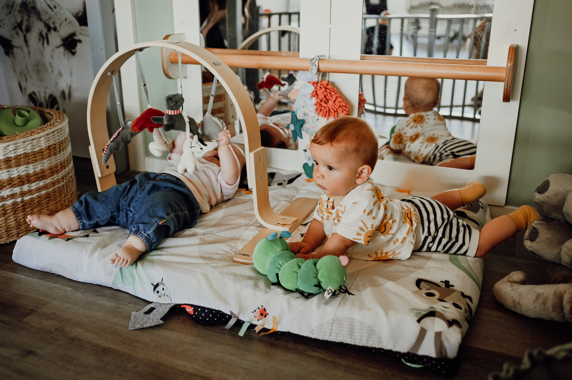 Twee peutertsjes op een speelmat in een kinderdagverblijf.